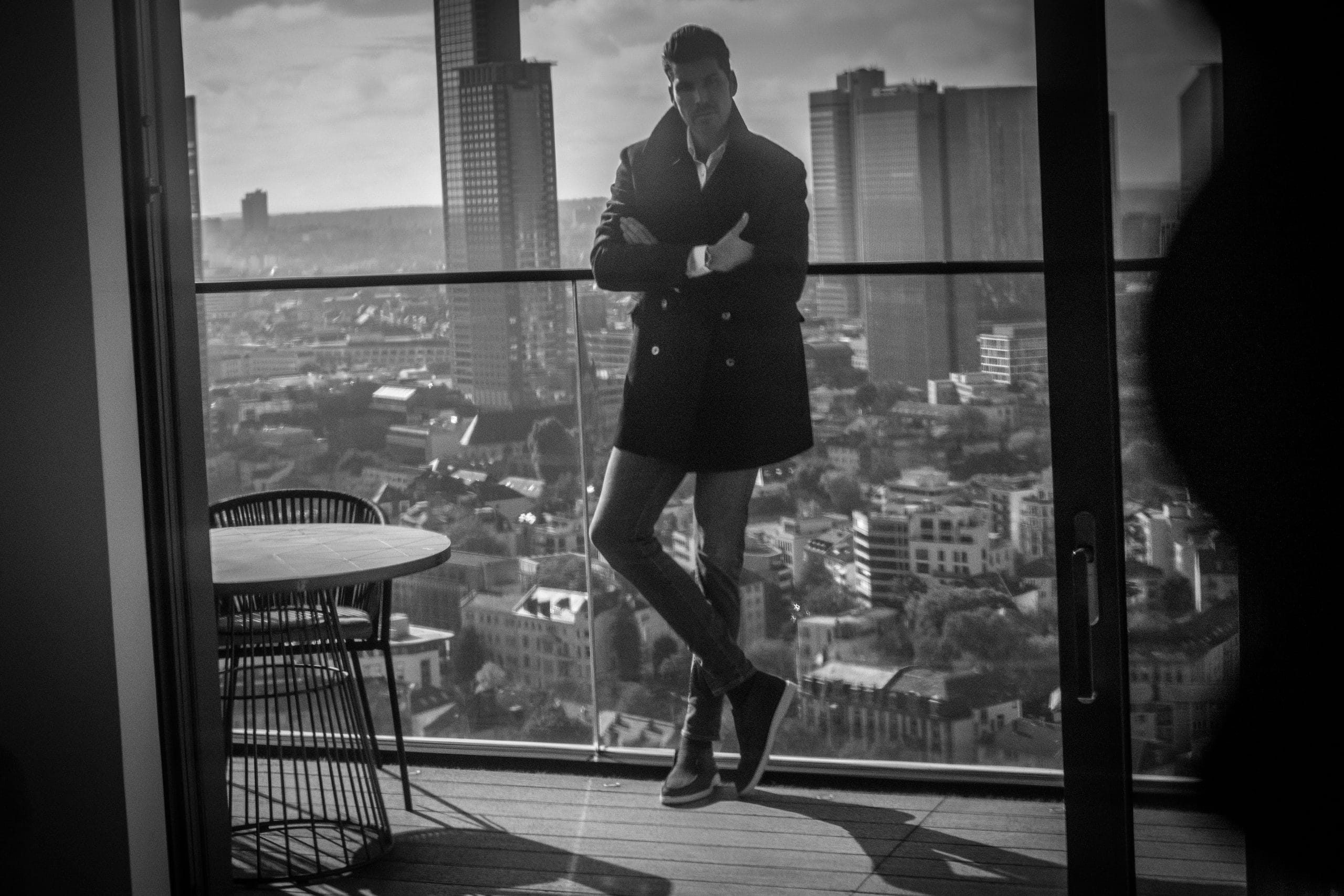Florian Tretter an der Fensterfront mit Frankfurter Skyline